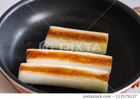 洋蔥放入煎鍋中煎熟 洋蔥放入煎鍋中煎熟 113579137