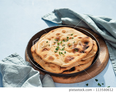 naan flatbread on blue, copy space naan flatbread on blue, copy space 113580612