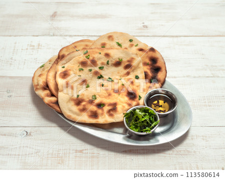 naan flatbreads on white wood, copy space naan flatbreads on white wood, copy space 113580614