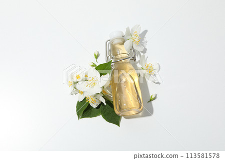 Jasmine flowers and glass bottle on white background, top view 113581578