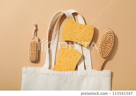 Brushes and sponges in cotton bag on beige background, top view Brushes and sponges in cotton bag on beige background, top view 113581587