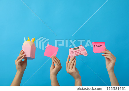 Stationery and exam record, in hands on a blue background. Stationery and exam record, in hands on a blue background. 113581661