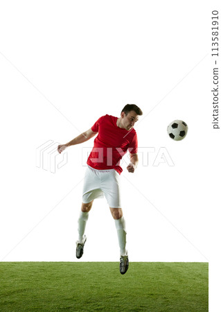 Full-length image of male football player in motion on field, training, hitting ball with head isolated on white background 113581910