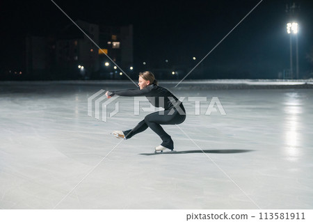 Beautiful young woman ice skating 113581911