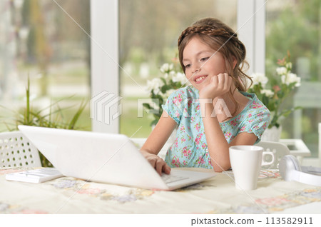 Cute and happy little girl children using laptop computer Cute and happy little girl children using laptop computer 113582911