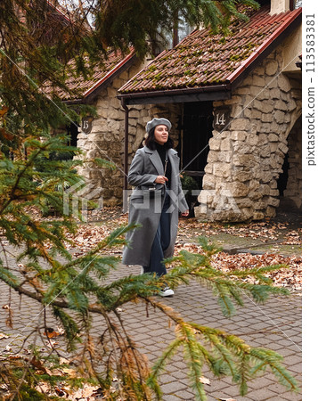 woman in autumn outfit walking by street woman in autumn outfit walking by street 113583381
