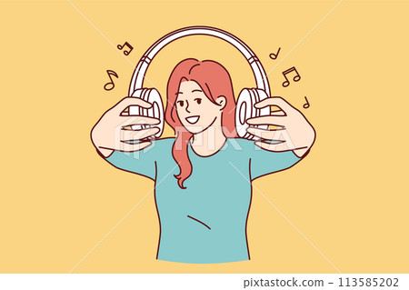 Wireless headphones in hands of woman inviting you to listen to popular songs or radio together Wireless headphones in hands of woman inviting you to listen to popular songs or radio together 113585202