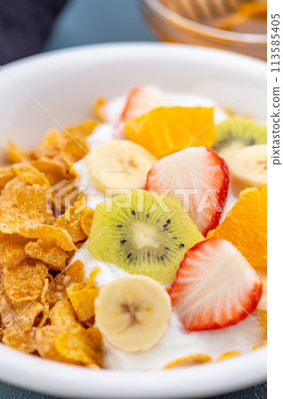 Close-up of breakfast cereal with yogurt and fruit on a dining table Close-up of breakfast cereal with yogurt and fruit on a dining table 113585405