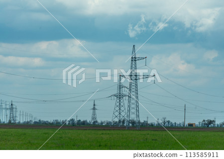 High voltage towers with sky background. Power line support with wires for electricity transmission. High voltage grid tower with wire cable at distribution station. Energy industry, energy saving High voltage towers with sky background. Power line support with wires for electricity transmission. High voltage grid tower with wire cable at distribution station. Energy industry, energy saving 113585911