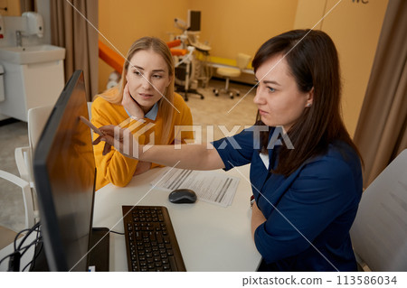 Two women doctor and patient discussing medical KT test results 113586034