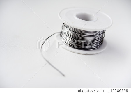 Tin-lead solder in coils on a white background. Materials for soldering. 113586398