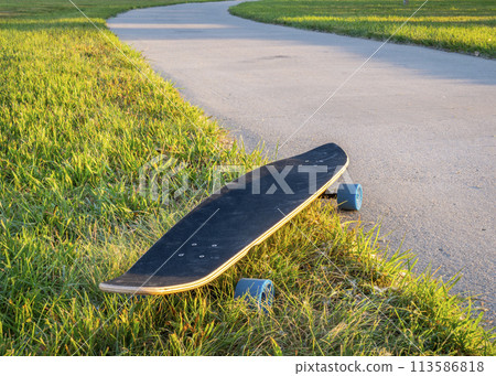 cruising longboard with blue wheels on a paved bike trail in summer scenery in northern Colorado 113586818