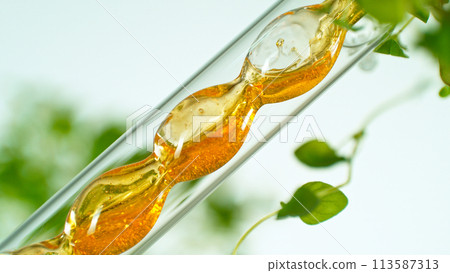 Getting essential oil from natural substances and flowers. Yellow oil flows in a spiral. 113587313