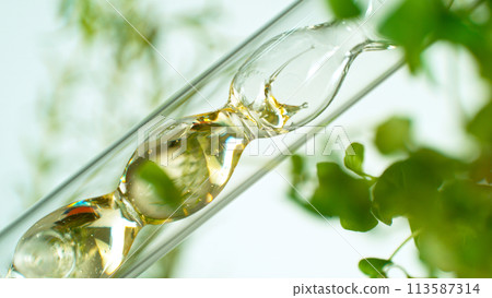 Getting essential oil from natural substances and flowers. Yellow oil flows in a spiral. 113587314