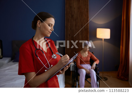 Doctor caregiver making notes about old senior woman patient Doctor caregiver making notes about old senior woman patient 113588223