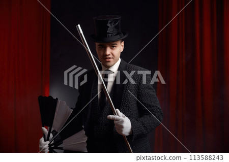 Magician performing miracle trick on stage using fan and cane Magician performing miracle trick on stage using fan and cane 113588243