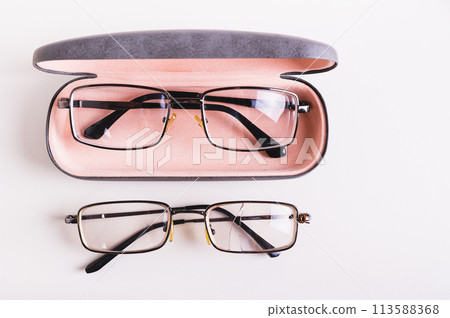 Whole glasses in a hard case and broken glasses on the table top view 113588368