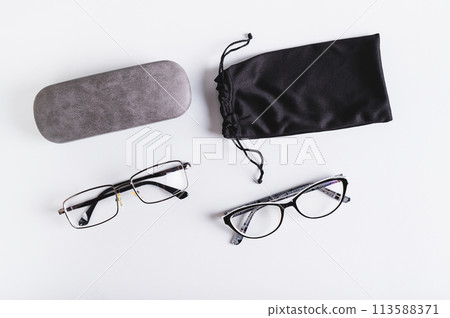 Eyeglasses, hard and soft storage case on blue background top view Eyeglasses, hard and soft storage case on blue background top view 113588371
