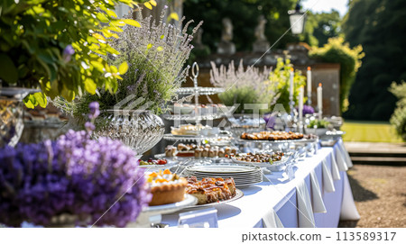 Wedding table decoration with lavender flowers, sweets and cake 113589317
