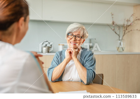 Female doctor examining older senior woman in doctor office or at home. Old woman lady patient and doctor have consultation in hospital room. Medicine healthcare medical checkup. Visit to doctor Female doctor examining older senior woman in doctor office or at home. Old woman lady patient and doctor have consultation in hospital room. Medicine healthcare medical checkup. Visit to doctor 113589633