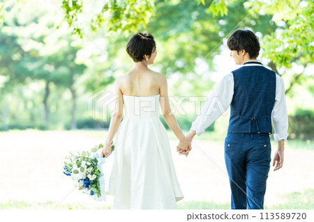 A bride and groom holding hands 113589720