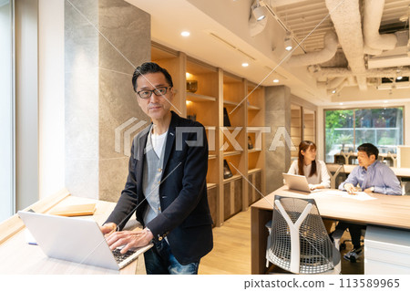 Middle-aged businessmen having a meeting in a coworking space Middle-aged businessmen having a meeting in a coworking space 113589965