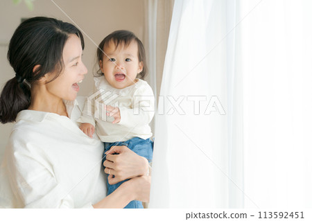 Portrait of a woman holding a baby 113592451