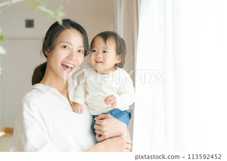 Portrait of a woman holding a baby 113592452