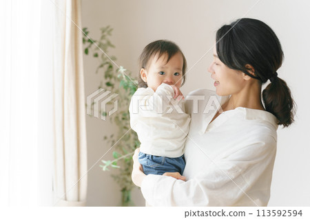 Portrait of a woman holding a baby 113592594
