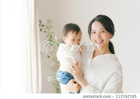 Portrait of a woman holding a baby 113592595