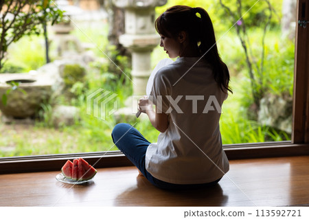Cute woman eating watermelon at home Cute woman eating watermelon at home 113592721