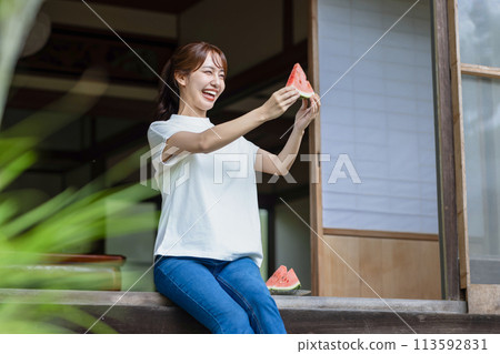 Cute woman eating watermelon on the porch 113592831