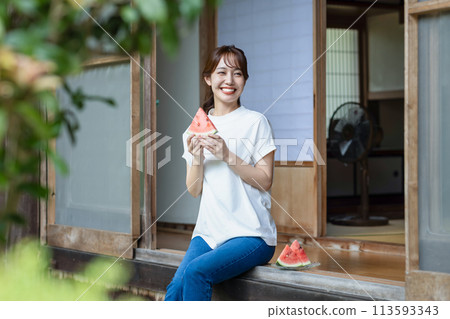 Cute woman eating watermelon on the porch Cute woman eating watermelon on the porch 113593343
