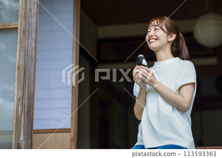 A cute woman eating rice balls on the veranda A cute woman eating rice balls on the veranda 113593361