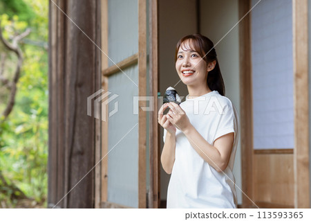 A cute woman eating rice balls on the veranda A cute woman eating rice balls on the veranda 113593365