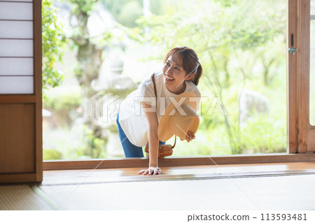 A woman peeking out from the veranda 113593481