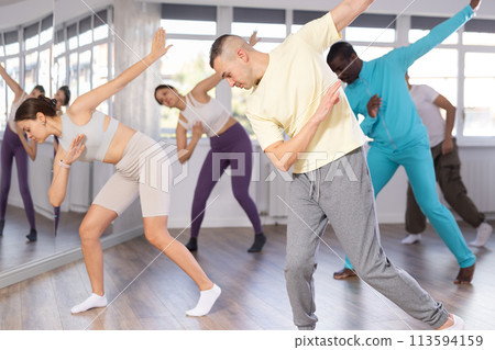 European guy with team of like-minded multinational people learn to elements of hip hop dance European guy with team of like-minded multinational people learn to elements of hip hop dance 113594159