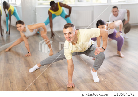 Young man doing leg exercises in training hall 113594172