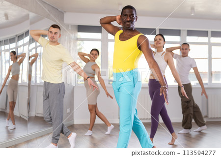 African man with team of like-minded multinational people learn to elements of contemporary dance 113594277