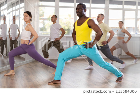 Middle-aged Afro-American man doing leg exercises in training hall 113594300