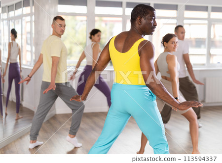 Middle-aged Afro-American man practicing aerobic dance in training hall Middle-aged Afro-American man practicing aerobic dance in training hall 113594337