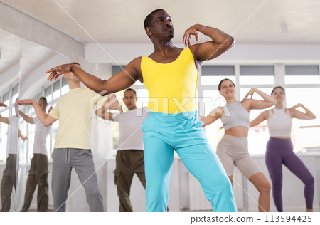 Middle-aged Afro-American man practicing jazz-funk dance in training hall Middle-aged Afro-American man practicing jazz-funk dance in training hall 113594425