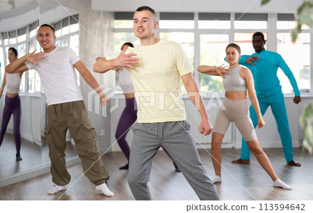 European guy with team of like-minded multinational people learn to elements of hip hop dance European guy with team of like-minded multinational people learn to elements of hip hop dance 113594642