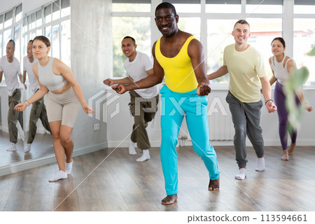 African man with team of like-minded multinational people learn to elements of contemporary dance African man with team of like-minded multinational people learn to elements of contemporary dance 113594661