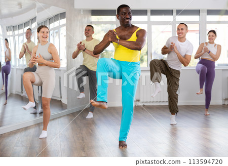 African man with team of like-minded multinational people learn to elements of contemporary dance African man with team of like-minded multinational people learn to elements of contemporary dance 113594720