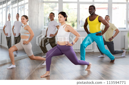 Young Asian woman practicing vigorous zumba with group Young Asian woman practicing vigorous zumba with group 113594771