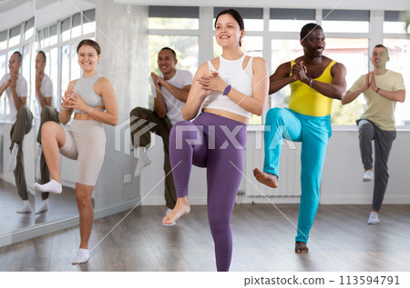 Happy girl and group of multinational young people practicing new modern dance techniques at dance school Happy girl and group of multinational young people practicing new modern dance techniques at dance school 113594791