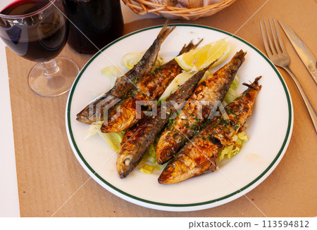 Fried sardines served with slice of lemon Fried sardines served with slice of lemon 113594812
