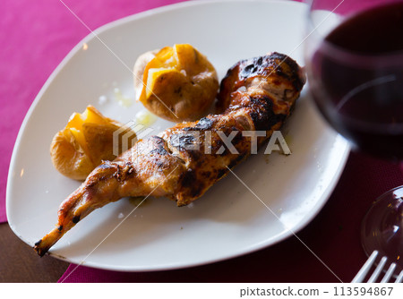 Tasty baked quarter of rabbit, served with pototoes at plate Tasty baked quarter of rabbit, served with pototoes at plate 113594867