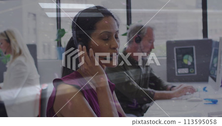 Biracial woman works in a busy office setting 113595058